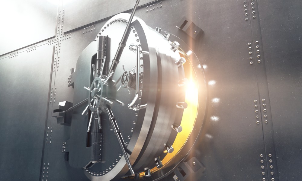 Off-center view of a large, circular bank vault door opening. Golden light shines out of the doorway toward the viewer.