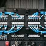 A network switcher has blue cables attached to it. Each cable is labeled by using cable management tools.