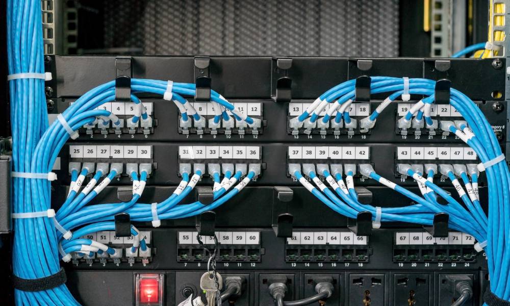 A network switcher has blue cables attached to it. Each cable is labeled by using cable management tools.