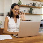 A young remote worker on a conference call with her digital team, sitting in her dedicated home office space.