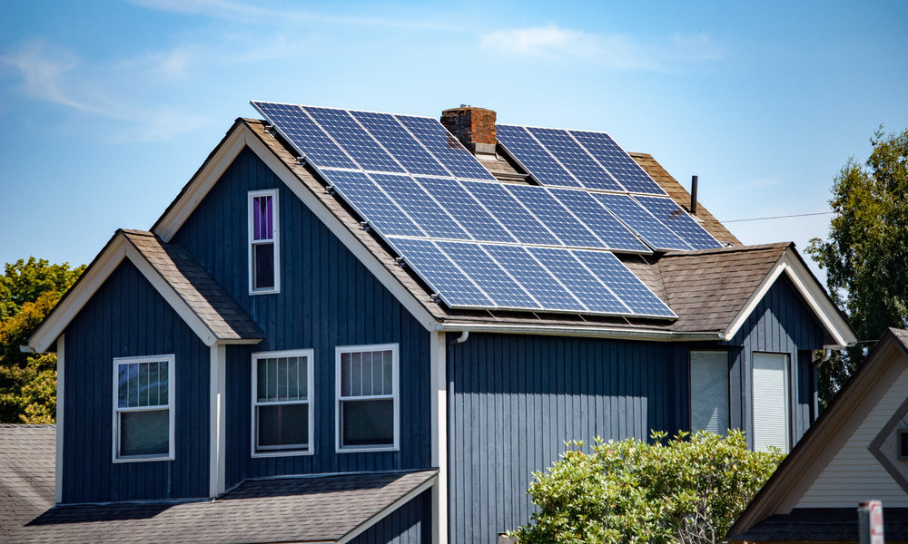 An American-style residential home with sustainable solar panels installed to the roof, soaking in solar energy from the sun.