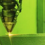 A close-up of a 3D printer using a method known as direct metal laser sintering to print a metal object.