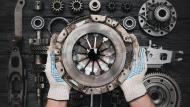 Close-up of a pair of hands holding up a used clutch basket. The person is wearing white and blue gloves on their hands.