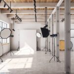 A large open concept photography studio with natural light pouring in and equipment scattered around.