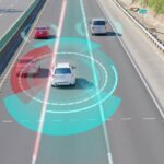 A vehicle driving down a three-lane highway. The vehicle features LiDAR technology and has red and blue graphics.