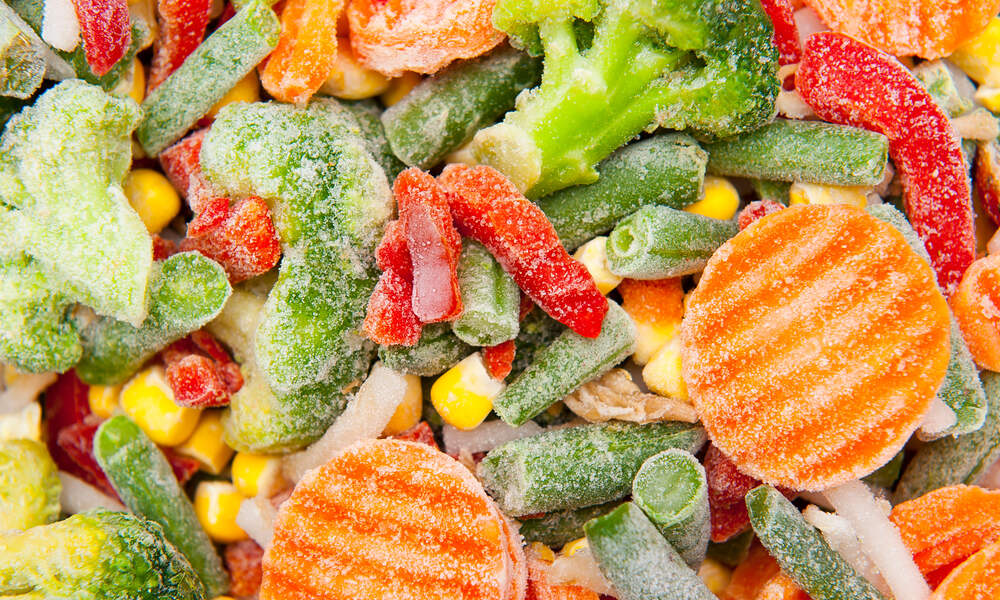 A medley of frozen vegetables includes carrots, broccoli, corn, green beans, red bell peppers, and cauliflower.