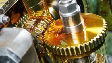 An industrial manufacturing facility with a moving gear covered in food-grade lubricant. The lubricant is honey-colored.