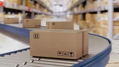 A close-up of a warehouse of cardboard boxes on conveyor belts, prepared for courier shipping and distribution.
