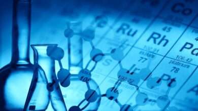 A molecular structure is superimposed over a periodic table of elements and the outlines of glass beakers and flasks.