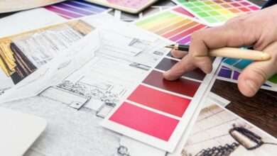 A close-up of a home designer working at the office, a house sketch with a color catalog for a renovation project.