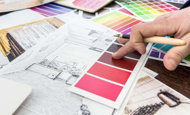 A close-up of a home designer working at the office, a house sketch with a color catalog for a renovation project.