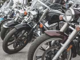 A close-up of several motorcycles parked in a neat row. Each bike is a different color and has a different front-end style.