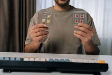 A man holds several mechanical keyboard switches while comparing parts for a custom mechanical keyboard project.
