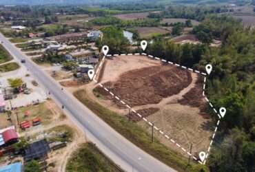 An aerial view of an open plot of land in a neighborhood. The plot is outlined by a dotted white line.