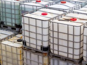 Intermediate bulk containers for chemicals stacked on top of one another. Some IBCs appear discolored.